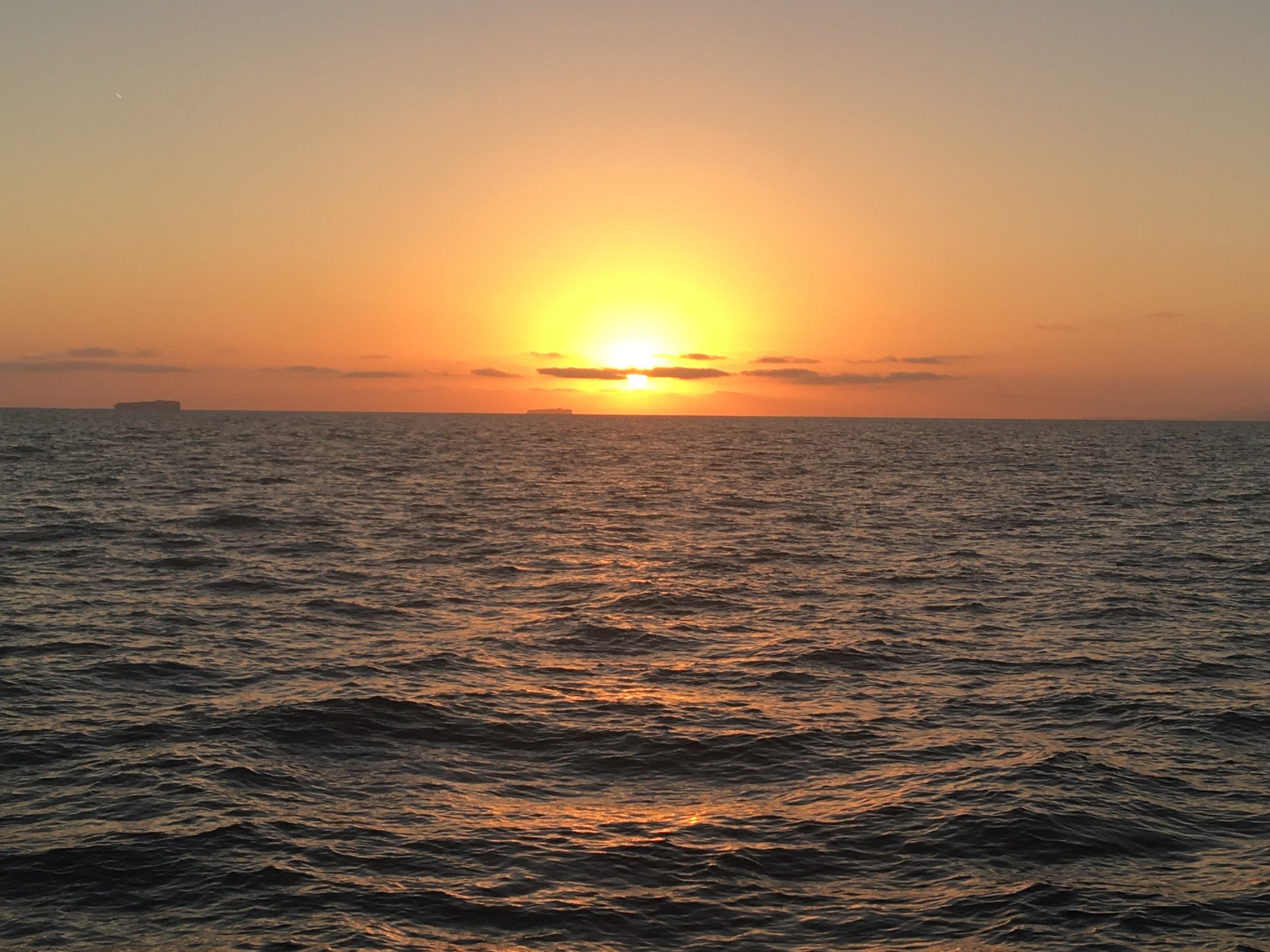 Orange sunset over the Pacific Ocean during a Sea Trek coastal cruise