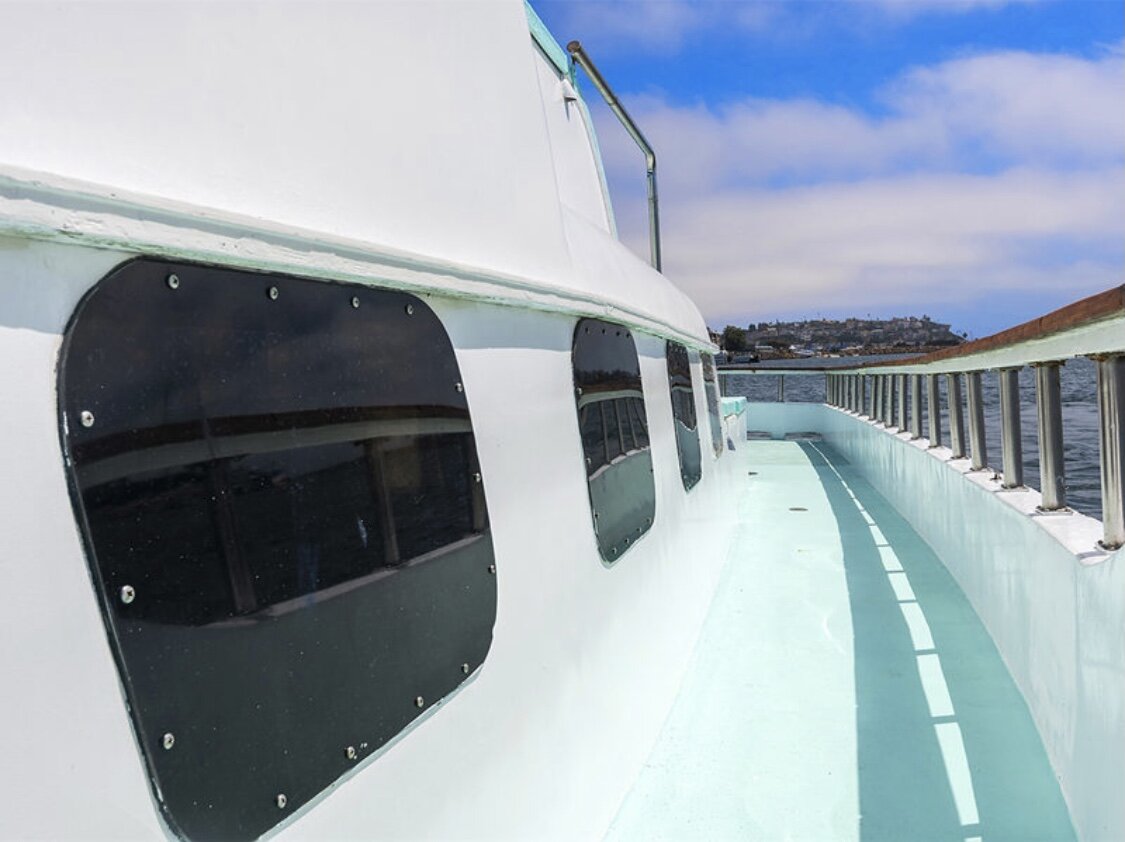 Side walkway and railings aboard Sea Trek with marina views