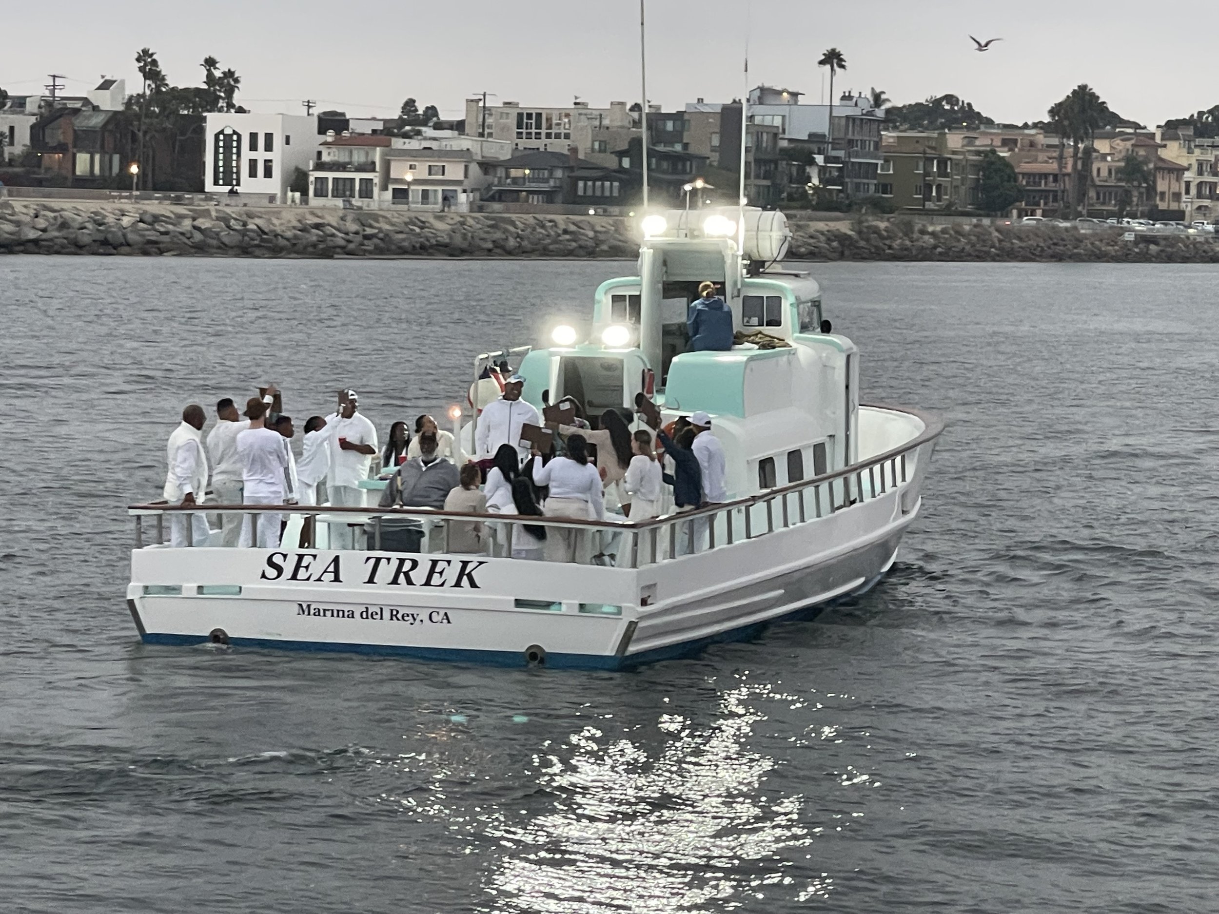 Guests in white aboard Sea Trek during a private ash scattering charter