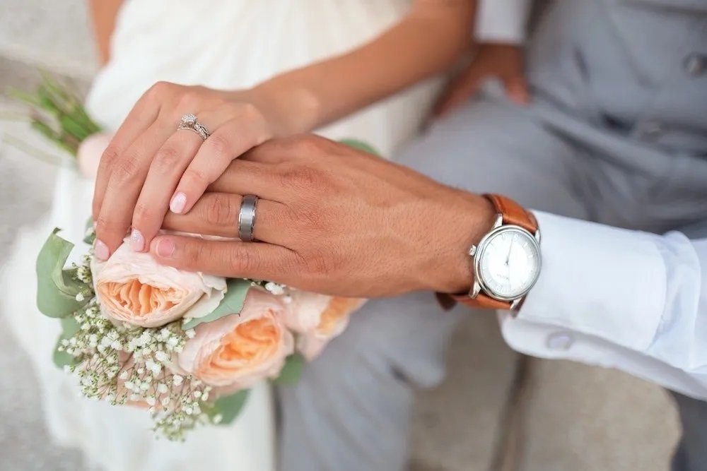 Close-up of wedding rings and flowers for a private celebration at sea